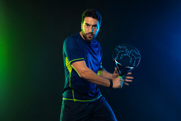 Padel Tennis Player with Racket in Hand. Paddle tenis, on a blue background. Sport concept. Download a high quality photo for the design of a sports app.
