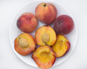 Juicy peaches on a white plate. Yellow-red large ripe peaches. Juicy fruits.