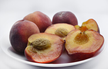 Juicy peaches on a white plate. Yellow-red large ripe peaches. Juicy fruits.