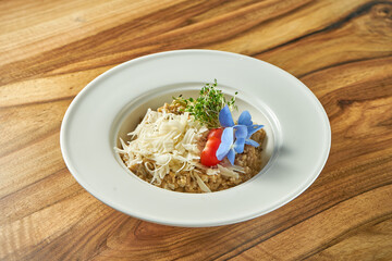 Oat risotto with cheese and tomato in a white plate. Vegetarian food