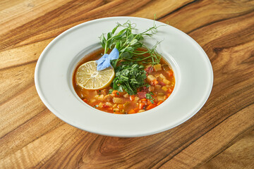 Vegetarian tomato soup with various vegetables in a plate.
