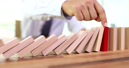 Insurance agent hand stopping falling wooden blocks closeup 4k movie. Insurance and risk prevention guarantees concept