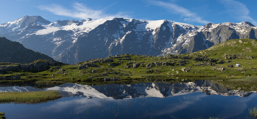 Naklejka na ściany i meble reflet des glaciers de la Meije sur un lac du plateau d'Emparis au refuge des Mouterres dans les Alpes en été