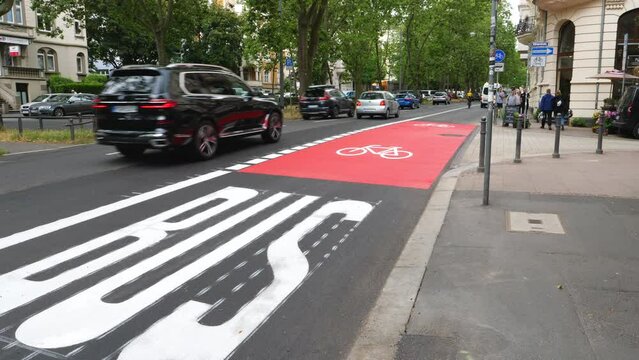 Wiesbaden, Germany - June 28, 2023: Traffic and combined bus and bicycle lane in the city center of Wiesbaden - some road users in the background