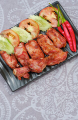 Deep Fried Preserved pork Spare Rib Northeastern style with fresh vegetable in black dish on table cloth in vertical frame, Flat lay with copy space