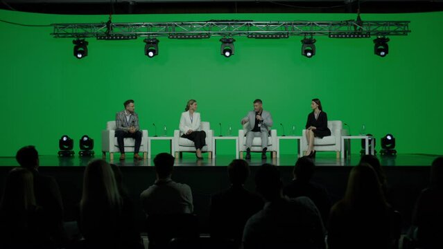 GREEN SCREEN CHROMA KEY Group of 4 experts sitting on stage, answering audience questions during the conference 