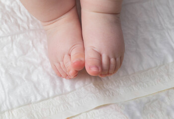 Baby feet on a white background. The concept of baby massage and baby skin care. Copy space for...