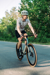 Fototapeta na wymiar Photo of a male cyclist not cycling outside the city on the road on a road bike.