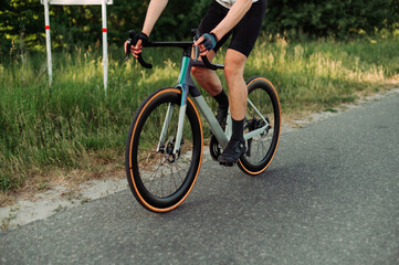 Fototapeta na wymiar Close up photo. A man rides a road bike on a country road.