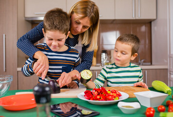 mother and two sons preparing food in the kitchen