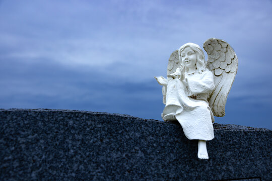 Ange avec colombe dans les mains, sur pierre tombale à l'heure bleue