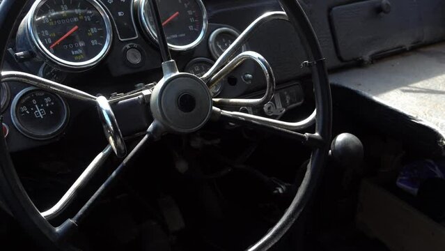 The steering wheel of a retro car, the interior of a vintage car, an abandoned car interior