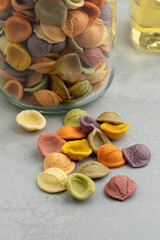 Colorful Italian raw Orecchiette Arcobaleno pasta in a glass bowl close up