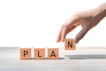 Placing a wooden block with the text "PLAN" on a wooden table. on a white background. Business concept for a successful growth process.PNG