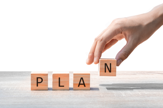 Placing a wooden block with the text "PLAN" on a wooden table. on a white background. Business concept for a successful growth process.PNG