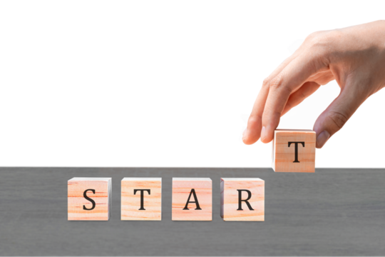 Placing a wooden block with the text "START" on a wooden table. on a white background. Business concept for a successful growth process.PNG