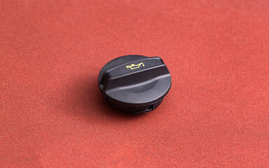 Black car oil filler plug on brown background, close-up