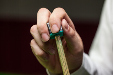 Snooker, billiard player, chalking the cue. closeup view