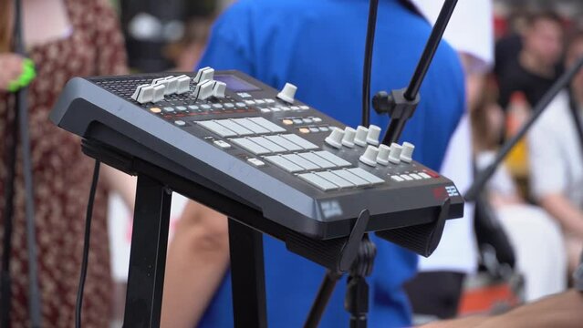 Musician playing electribe sampler or midi synthesizer at a street music festival. Cover band performing at open air, Keyboardist synthesizer playing
