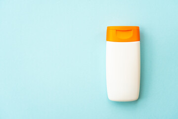 Sun screen products on blue background with palm leaves. Sun protection for summer holidays, beach relax and sunbathing. Flat lay with space for text.