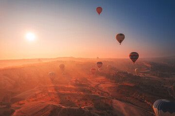 Amazing sunrise landscape in Cappadocia with colorful hot air balloon fly in sky over deep canyons, valleys. Turkey banner travel Concept