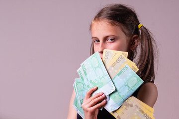 Conceptual image: Financial education, literacy and investing. Portrait of young attractive beautiful girl with stack of Euro bills. Copy space for text or design.