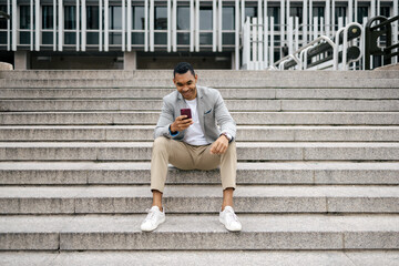 Man sitting on stairs using smartphone