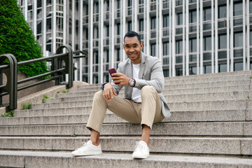 Man sitting on stairs using smartphone