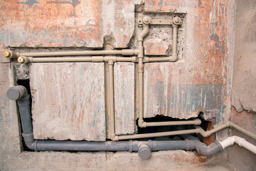 Transfer of water pipes and sewerage drain in the wall. Bathroom plumbing installation, background. Replacement of iron pipes with polypropylene ones.