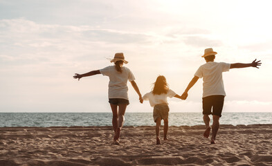 Happy asian family enjoy the sea beach. father, mother and daughter having fun playing beach in summer vacation on the ocean beach. Happy family with vacation time lifestyle concept.