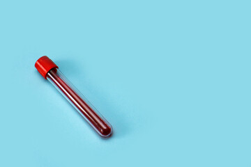 test tube with blood on a blue background with copy space