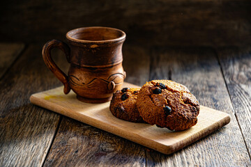 Oatmeal cookies and a cup of coffee on a wooden table.