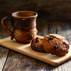 Oatmeal cookies and a cup of coffee on a wooden table.