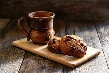 Oatmeal cookies and a cup of coffee on a wooden table.