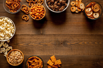 Obraz na płótnie Canvas Many bowls with different salty snacks - chips pretzels nuts