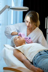 Obraz premium PRP ttherapy in beauty clinic, cosmetologist doing injections to woman's face to cure problem skin.