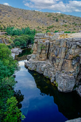 Fototapeta na wymiar A spectacular pool formed in the bed of the Barbellido River is known as the Well of the Walls. The erosion of wind and water over centuries has carved two immense walls between which the water flows.