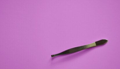 tweezers on a pink background, modeling, decoration and lamination of eyebrows, medical tweezers, a...