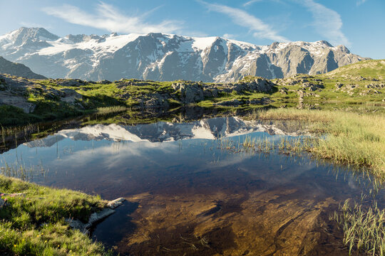 reflet des glaciers de la Meije sur un lac du plateau d'Emparis au refuge des Mouterres dans les Alpes en &eacute;t&eacute;