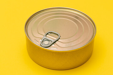 Unopened Tin Can with Blank Edge on Yellow Background. Canned Food. Aluminum Can for Safe and Long Term Storage of Food. Steel Sealed Food Storage Container