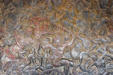 Hindu mythology battle scenes masterfully chiseled into the stone walls of an ancient Khmer temple, epitomizing the craftmanship of ancient artists.