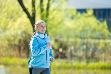 Naklejka premium Woman in blue blazer running in th morning park