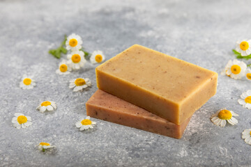 Natural homemade soap with chamomile flowers on a marble background. Spa procedure. Beauty concept. Body skin care. Place for text. copy space.