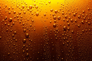 Close-up of water drops on yellow-orange surface, background - 617874761