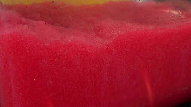 Machine making Ice Slushy Drinks. Tanks cooling and mixing beverage juice dispenser or juice cooler on counter on street food festival. Frozen drink Iced Juice Mixer. Juicer Containing Smoothie