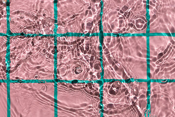 Water texture on pink checkered pattern background on the noon sunlight. 