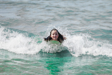 adorable girl plays in the sea by the shore