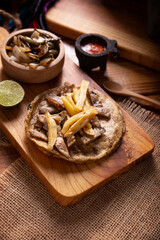 Beef steak taco with french fries. Very popular taco in Mexico called Taco de Bistec or Carne Asada, homemade roast beef served on a corn tortilla. Mexican street food.