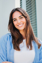 Vertical portrait of a joyful and adorable teenage brunette woman posing for a college promotion...