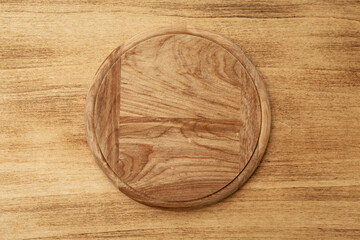Empty round pizza board on wooden old background, top view